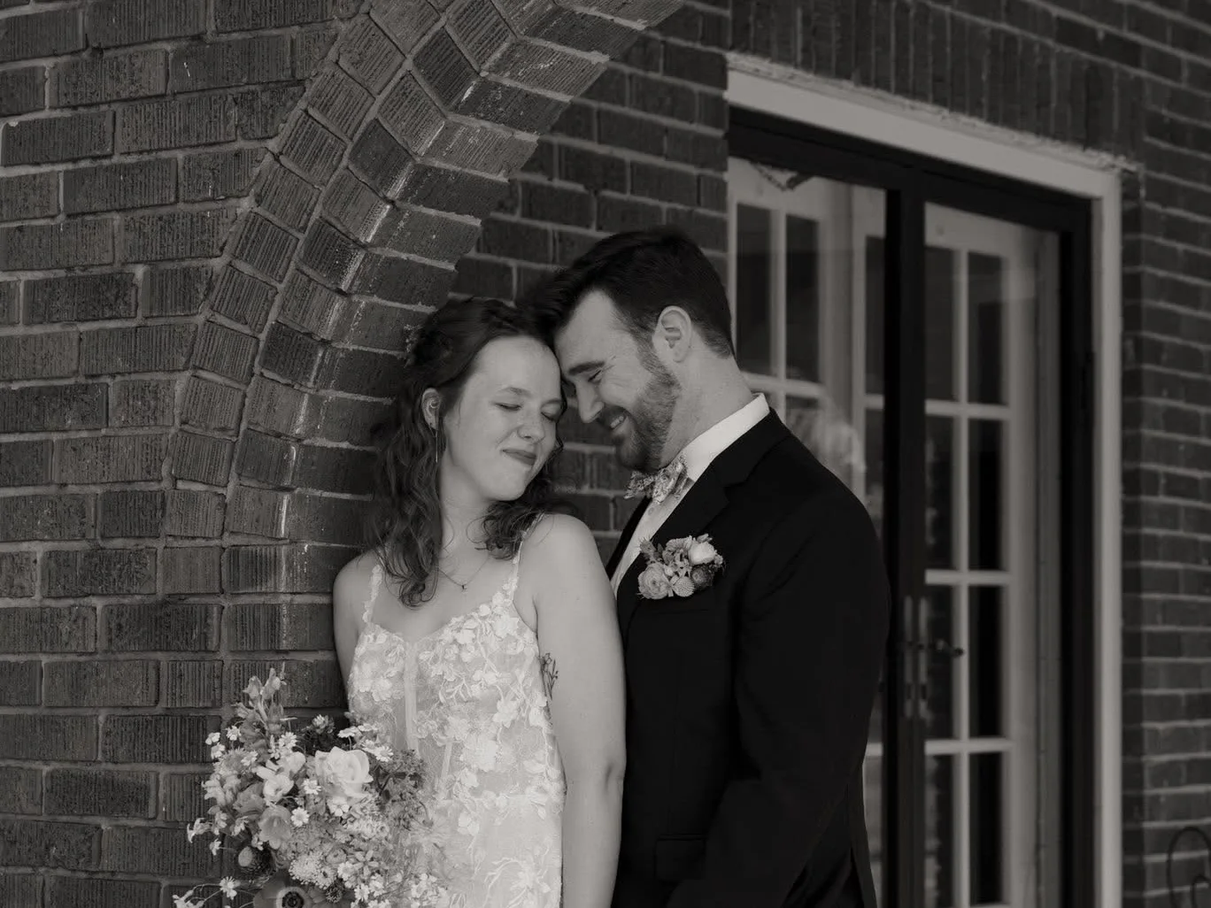 A bride and groom standing together in a garden